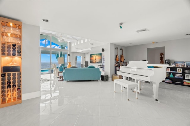 interior space with a water view, lofted ceiling, and light tile patterned floors