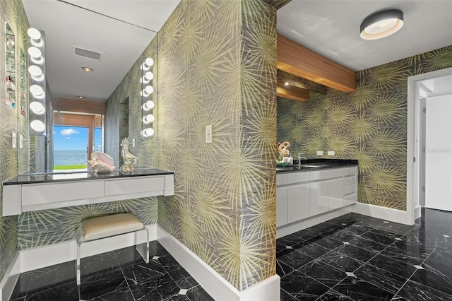 bathroom with marble finish floor, visible vents, and wallpapered walls