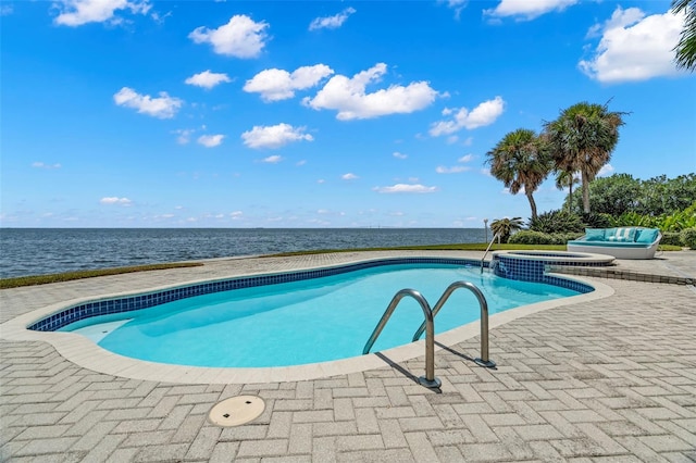 view of swimming pool with an in ground hot tub, a patio, and a water view