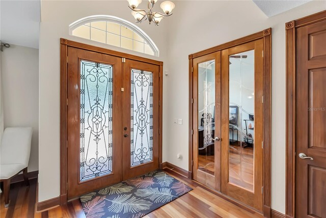 entryway featuring a notable chandelier, wood-type flooring, and french doors