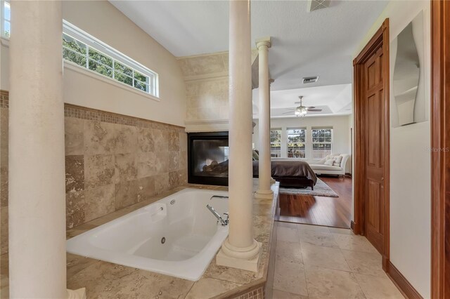 bathroom with plenty of natural light, ceiling fan, hardwood / wood-style floors, and ornate columns