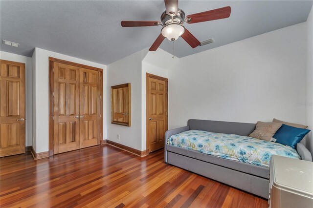 bedroom featuring ceiling fan, a closet, and wood-type flooring