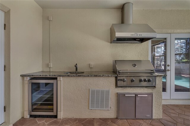 kitchen featuring sink, french doors, ventilation hood, tile patterned flooring, and beverage cooler