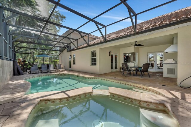 view of pool with ceiling fan, glass enclosure, an in ground hot tub, and a patio area