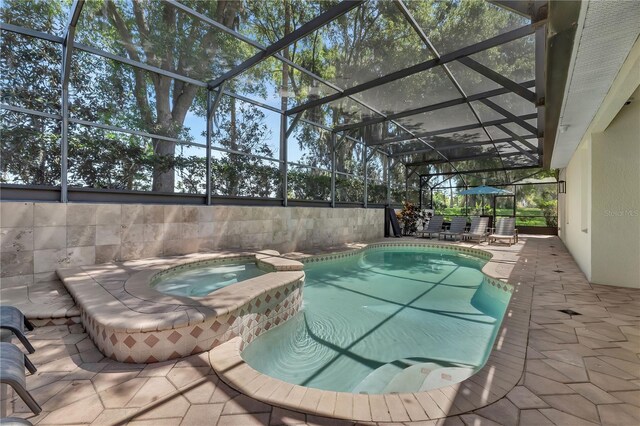 view of pool with an in ground hot tub, a patio area, and a lanai