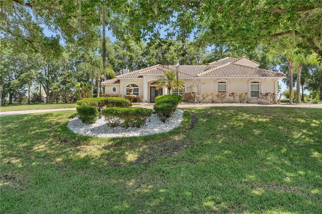 mediterranean / spanish-style house featuring a front yard