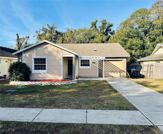 view of front of home with a front yard, concrete driveway, fence, and an attached garage