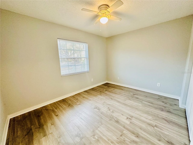 unfurnished room featuring light wood-type flooring, ceiling fan, a textured ceiling, and baseboards