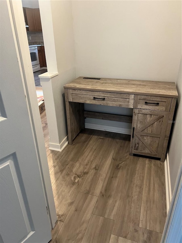 interior details featuring baseboards, decorative backsplash, and wood finished floors