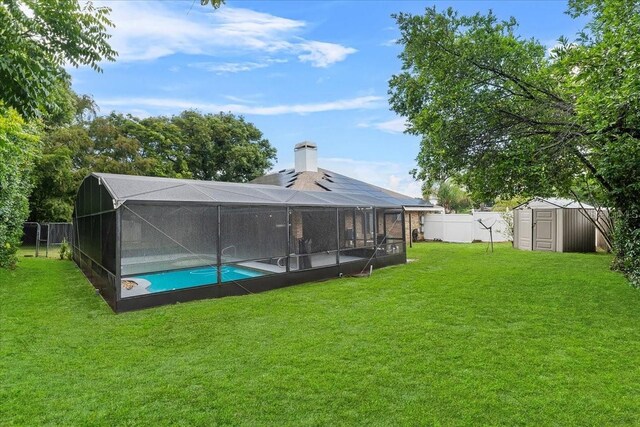 exterior space featuring a fenced in pool, a lawn, a storage unit, and a lanai