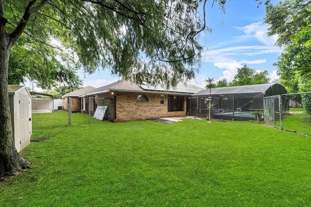 back of property with a fenced in pool and a yard