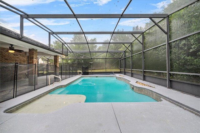 view of swimming pool featuring ceiling fan, a patio area, and glass enclosure