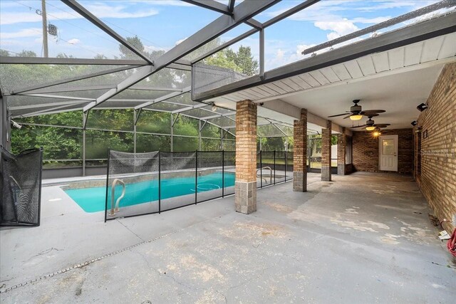 view of swimming pool featuring ceiling fan, a patio area, and glass enclosure