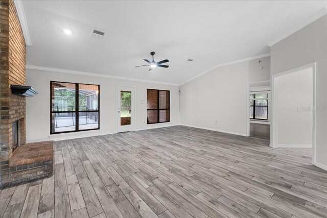 unfurnished living room featuring brick wall, light hardwood / wood-style flooring, plenty of natural light, and a brick fireplace