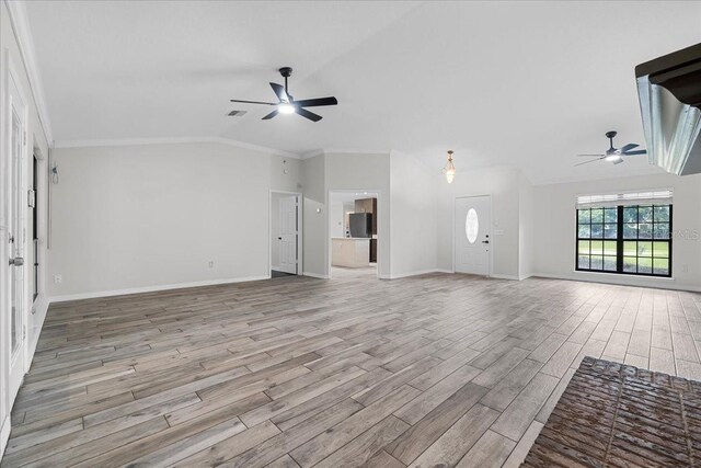 unfurnished living room with lofted ceiling, crown molding, ceiling fan, and light hardwood / wood-style floors