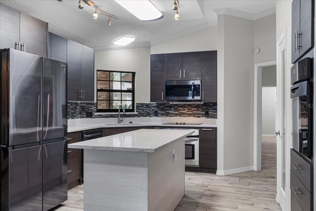 kitchen with track lighting, crown molding, tasteful backsplash, sink, and appliances with stainless steel finishes