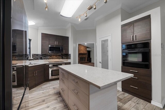 kitchen with black appliances, sink, decorative backsplash, and a kitchen island