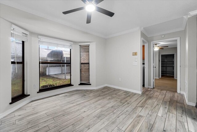 empty room with a wealth of natural light, ceiling fan, and light hardwood / wood-style floors