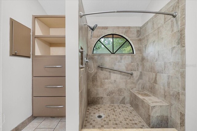 bathroom with a tile shower and tile patterned floors