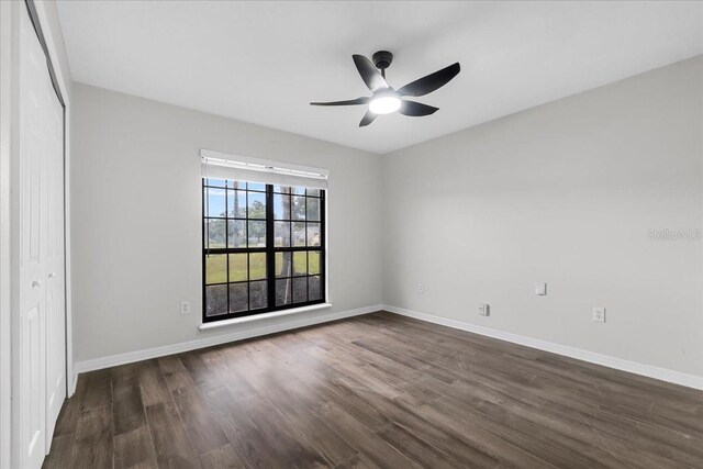 empty room with dark wood-type flooring and ceiling fan