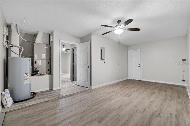 interior space featuring electric water heater, light hardwood / wood-style flooring, and ceiling fan