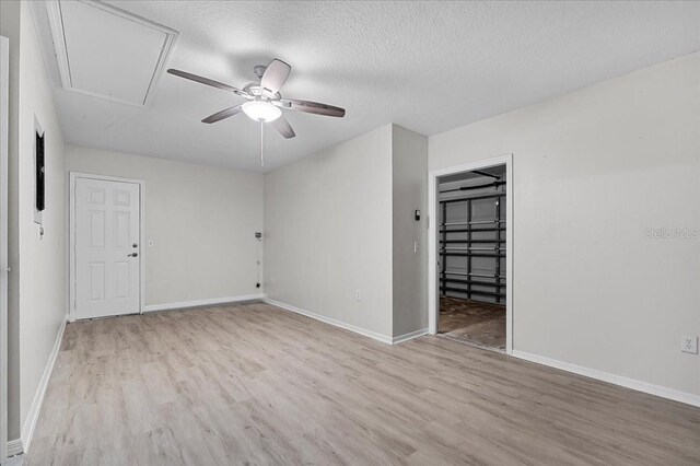 spare room with a textured ceiling, light hardwood / wood-style flooring, and ceiling fan