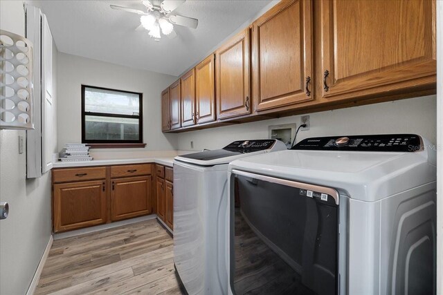 laundry room with ceiling fan, washer and dryer, cabinets, and light hardwood / wood-style flooring