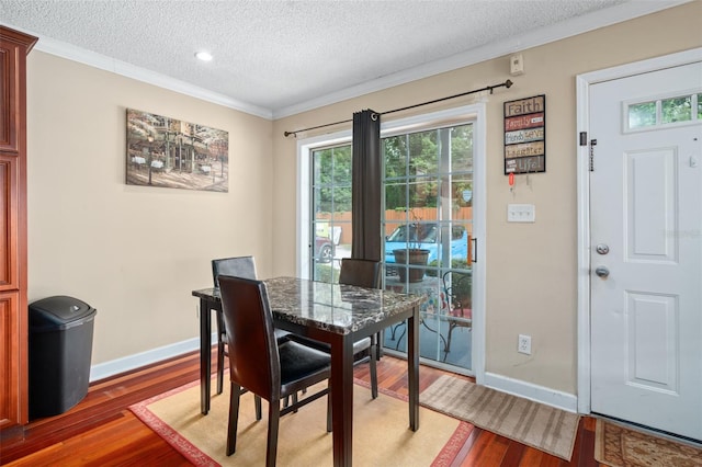 dining space featuring crown molding, dark wood-type flooring, and a textured ceiling