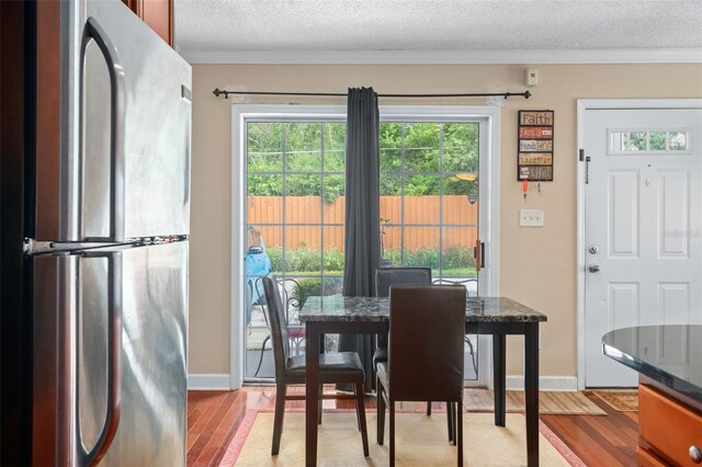 dining room featuring a textured ceiling and light wood-type flooring