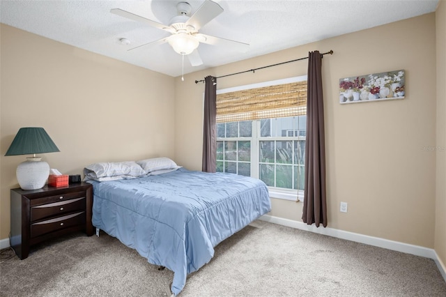 carpeted bedroom with ceiling fan and a textured ceiling