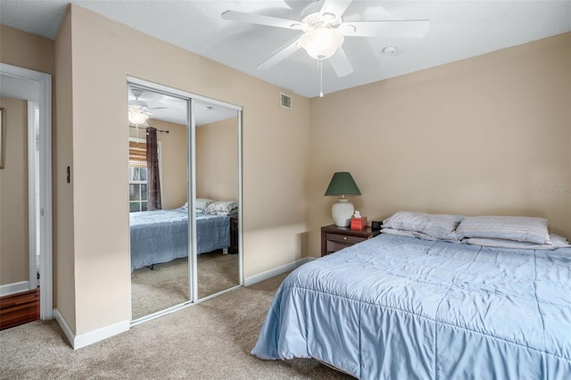 carpeted bedroom featuring ceiling fan and a closet