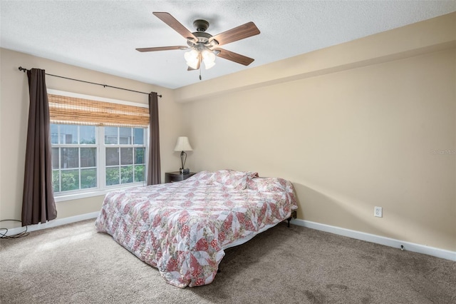 carpeted bedroom featuring a textured ceiling and ceiling fan