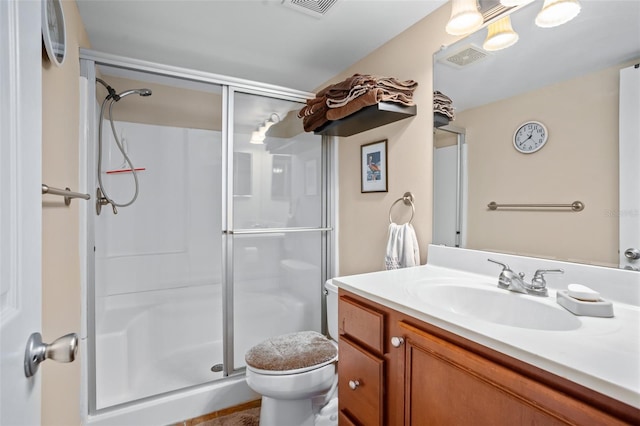 bathroom featuring a shower with shower door, toilet, and vanity