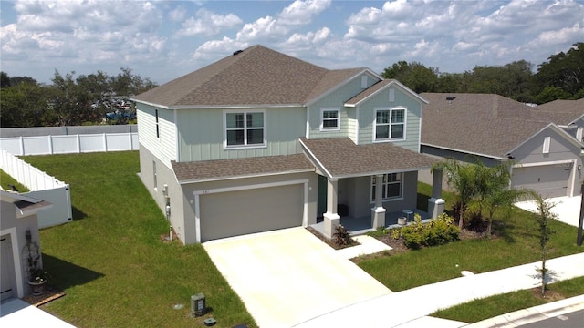 view of front facade with a shingled roof, fence, concrete driveway, a front yard, and covered porch