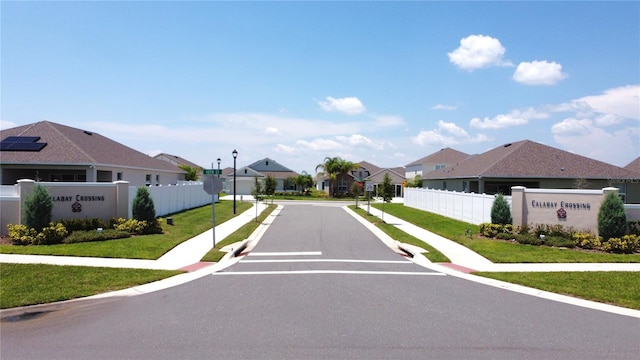 view of road with a residential view, sidewalks, and street lighting