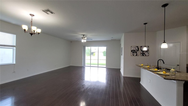 unfurnished living room with ceiling fan with notable chandelier, dark hardwood / wood-style floors, and sink