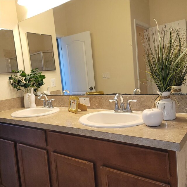 bathroom with vanity and a shower with door