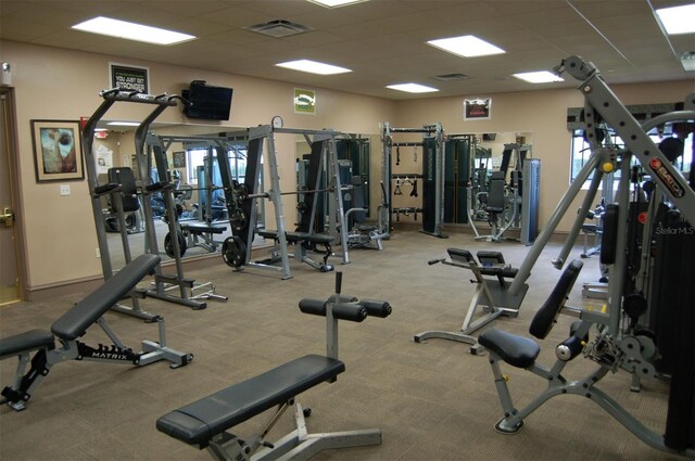 workout area with light carpet and a paneled ceiling