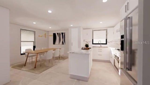 kitchen with sink, a kitchen island, white cabinetry, and light tile patterned floors