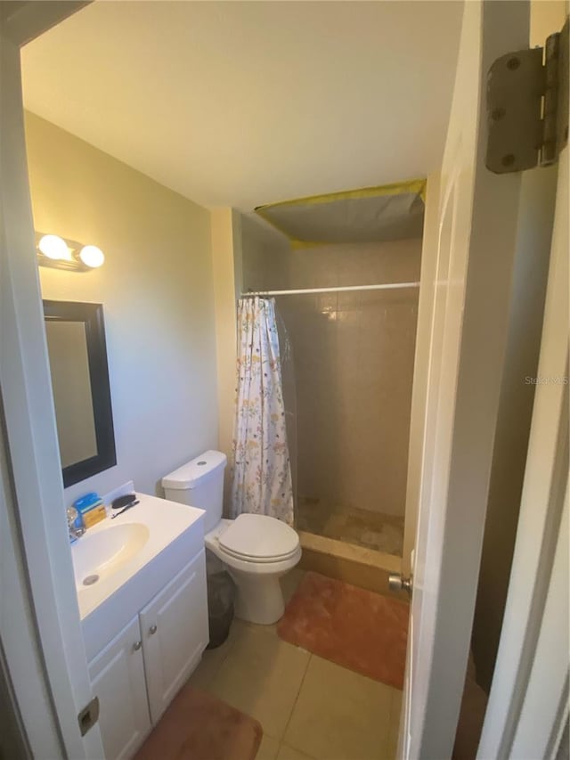 bathroom with tile patterned flooring, vanity, toilet, and a shower with curtain