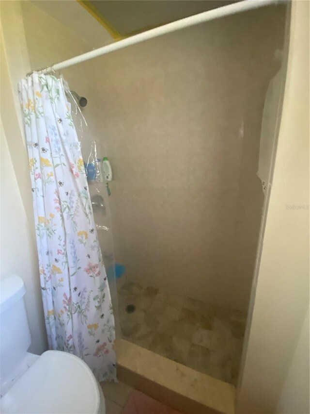 bathroom featuring toilet and a shower with shower curtain