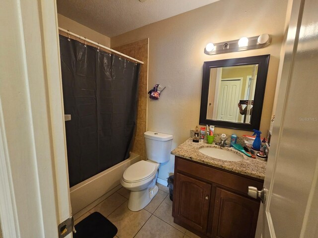 full bathroom featuring shower / bath combo with shower curtain, vanity, a textured ceiling, toilet, and tile patterned floors