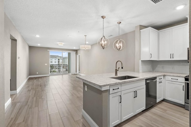 kitchen featuring white cabinetry, stainless steel dishwasher, sink, light stone countertops, and kitchen peninsula