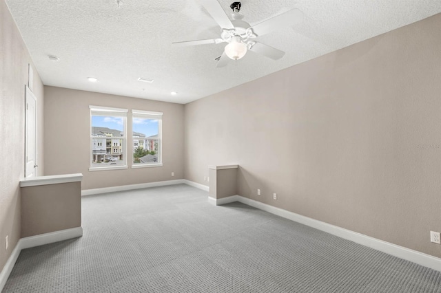 carpeted empty room with a textured ceiling and ceiling fan