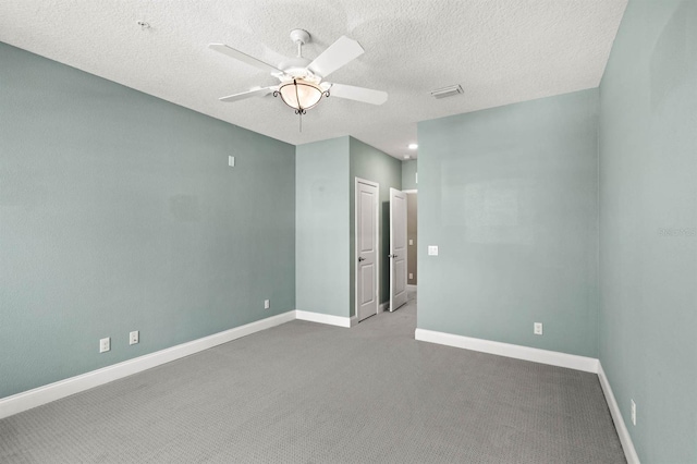 carpeted spare room featuring ceiling fan and a textured ceiling