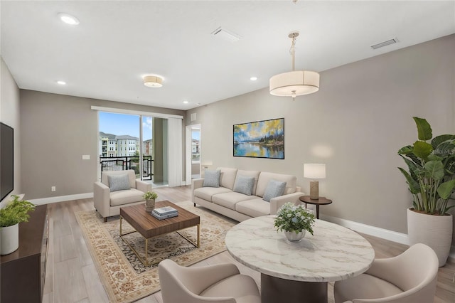 living room with light wood-style flooring, recessed lighting, visible vents, and baseboards