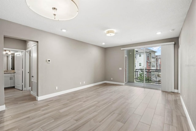 spare room featuring light wood-style flooring and baseboards