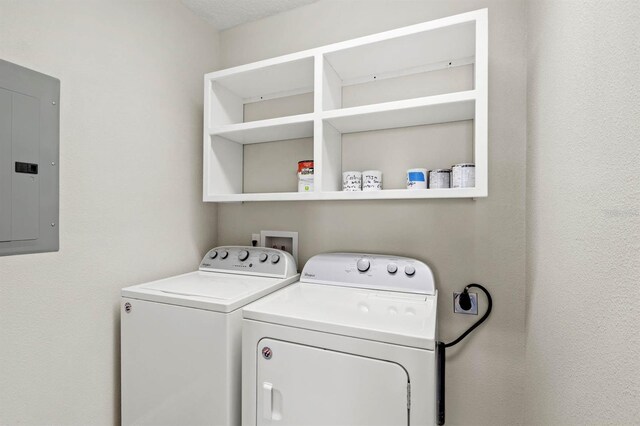 laundry room with laundry area, washing machine and clothes dryer, and electric panel