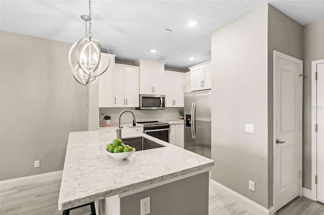 7573 Laureate Blvd Unit 1301, Orlando, FL 32827 - kitchen with appliances with stainless steel finishes, baseboards, a peninsula, a sink, and recessed lighting