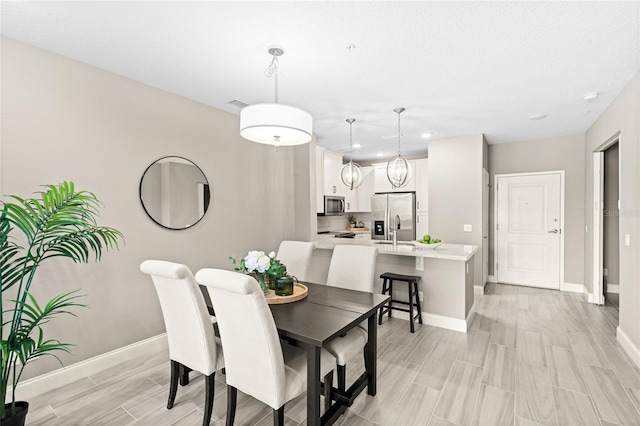 7573 Laureate Blvd Unit 1301, Orlando, FL 32827 - dining area with baseboards, wood tiled floors, and recessed lighting